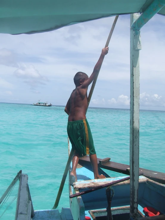 a  standing on top of a boat in the ocean