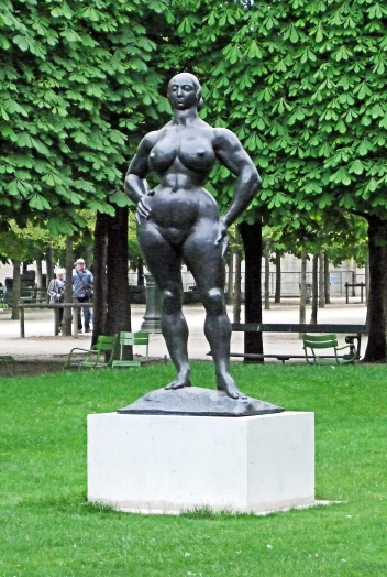 a sculpture of a woman is standing on the grass