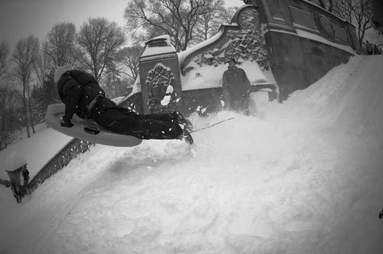 a snow boarder jumps from his board into the air