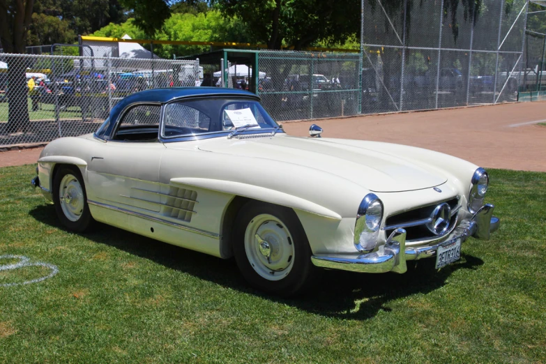 an old mercedes benz speedshow parked on a green lawn