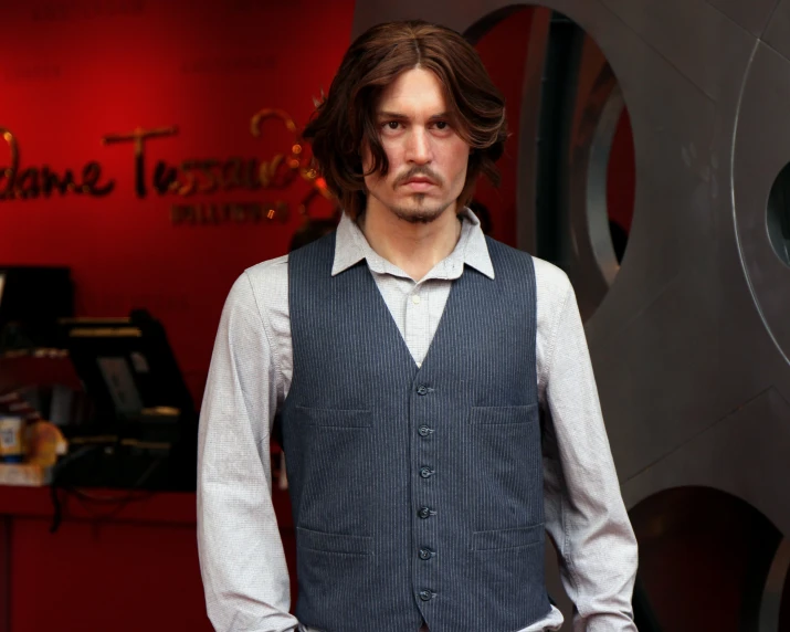 a young man standing in front of a sign