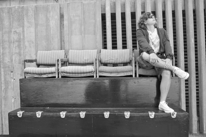 woman with hat sitting on outdoor bench looking up at sky