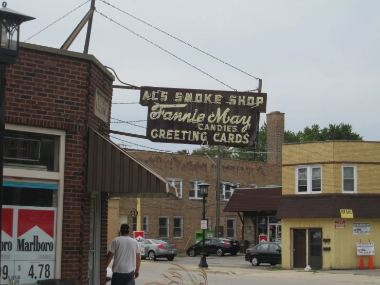 a man standing next to cars parked in front of a store