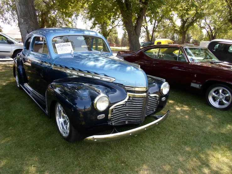 the classic car is parked in the grass