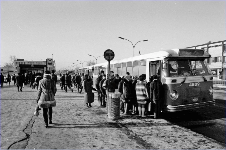 people walking down the street near the buses