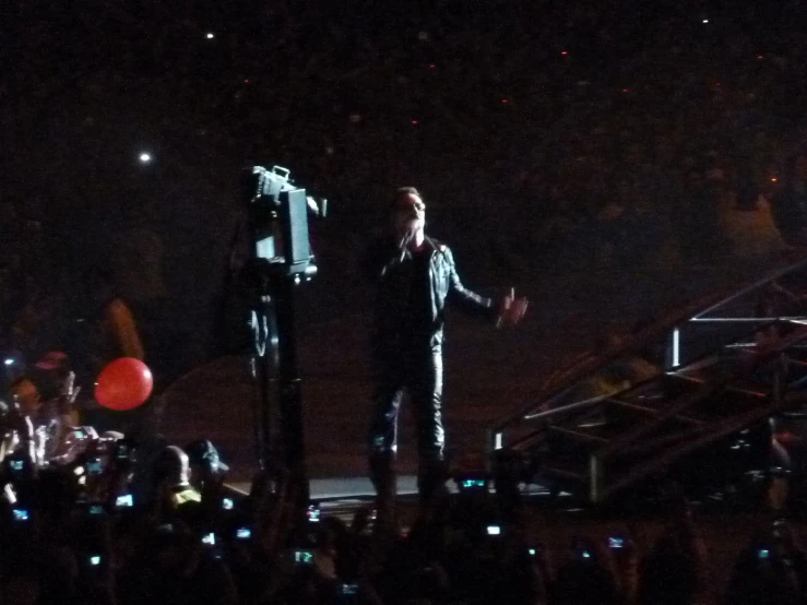 two men standing at microphones in front of some fans