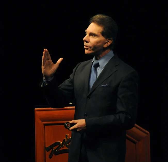 a man giving a speech in front of microphones