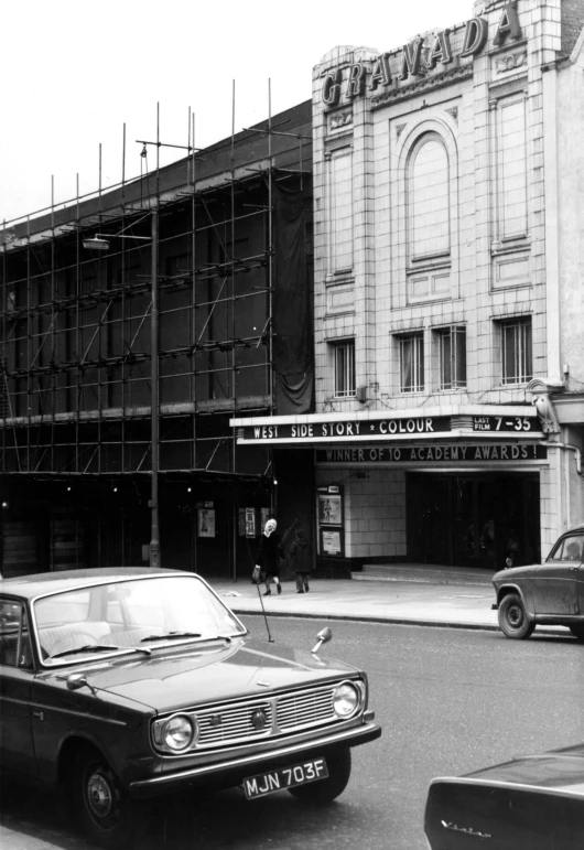 a old vintage po of a car parked in front of an empty building