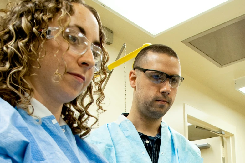 a man is holding a toothbrush and a woman is wearing glasses