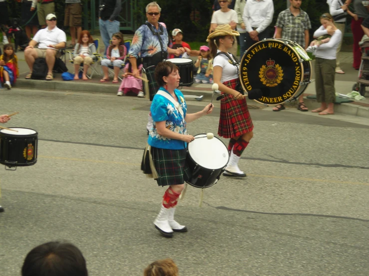 some young people are playing drum on the street