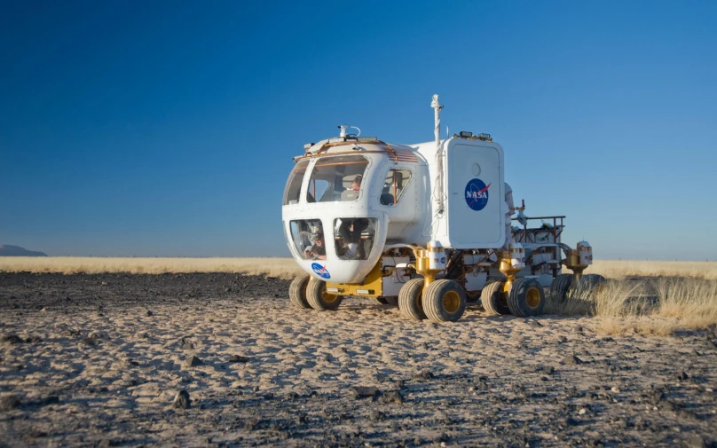 a vehicle sitting in the middle of an arid field