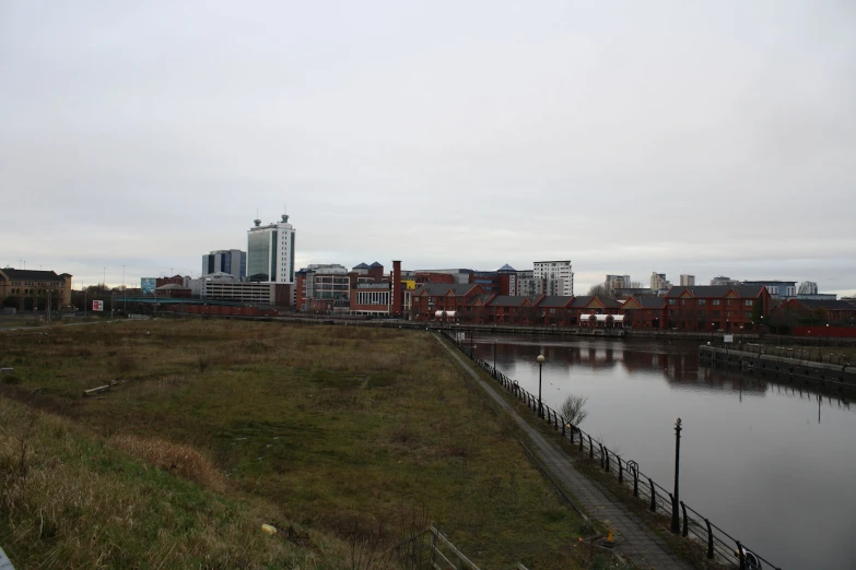 a river running past a city next to tall buildings