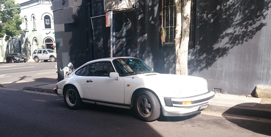 a white sports car parked in front of an old building