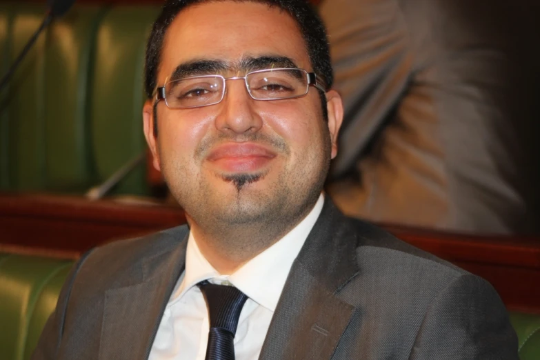 man wearing glasses in a suit and tie in a courtroom