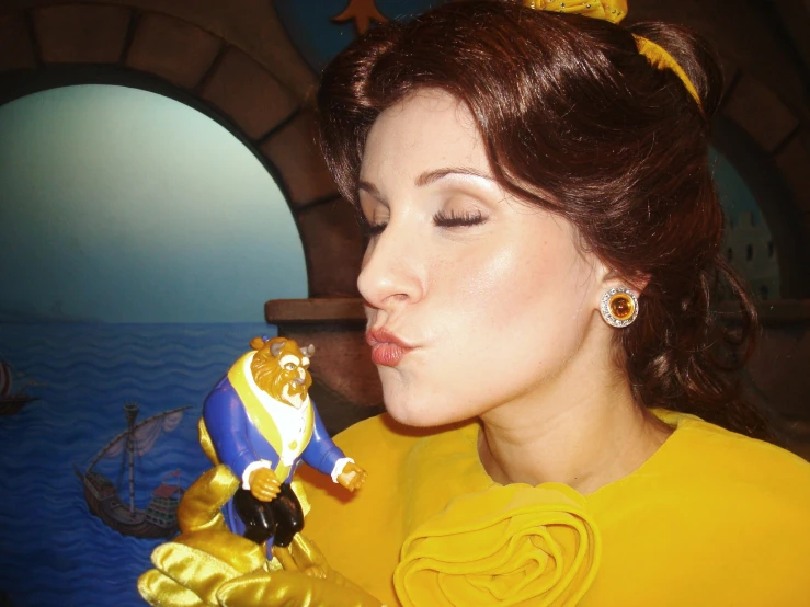 woman in yellow with disney figurine licking it