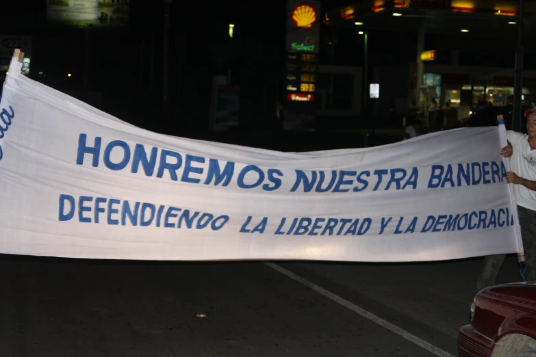 a man holds up a banner in a city