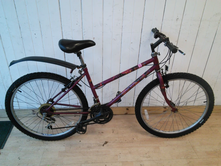 a red bike parked against a white wall