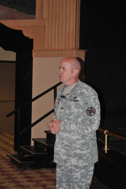 a man in a military uniform standing next to a banister