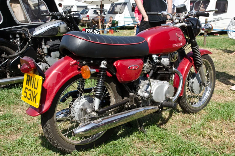 a red motorcycle with two yellow signs and people in the background