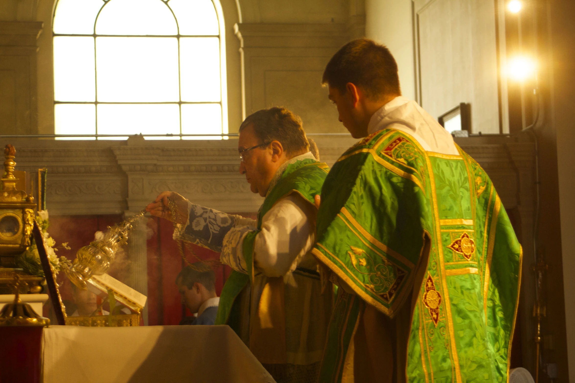 a priest wearing a green and gold outfit