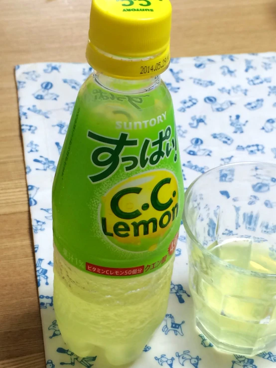 a bottle of lemonade and an empty glass on a table