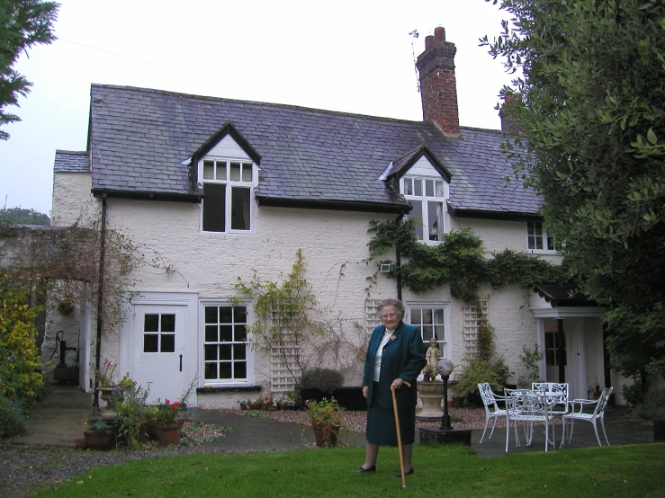 a woman with a cane standing in front of a building