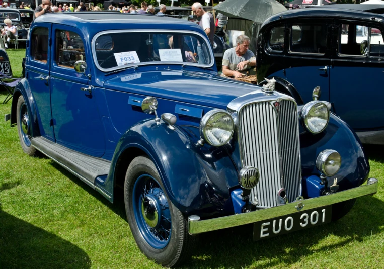 an old style car on a field of grass