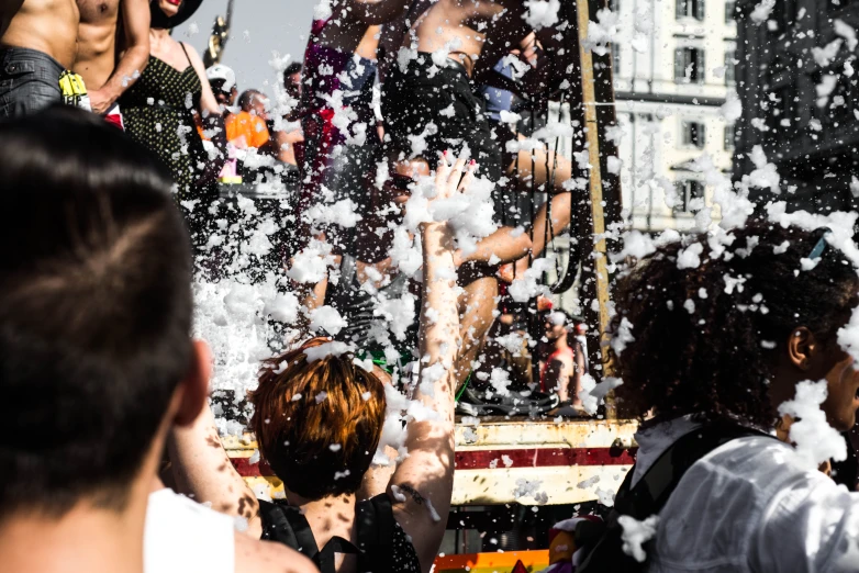 people are blowing bubbles on a street with one of them in the air