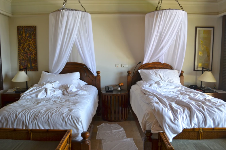 a room with two beds and curtains over them