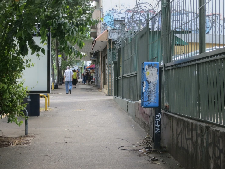 a blue sign sitting on the side of a walk way