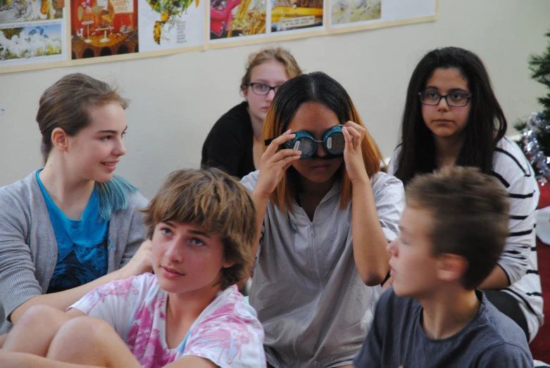 a group of s looking into binoculars in a classroom