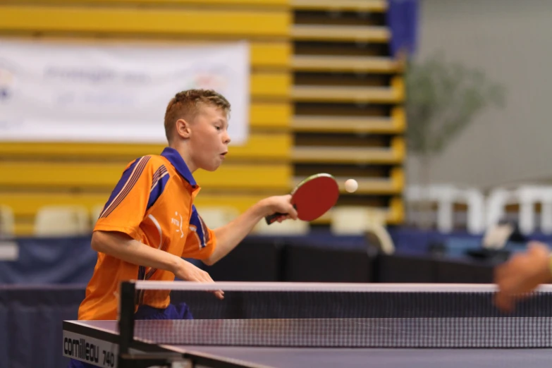 a little boy with a racket on a court