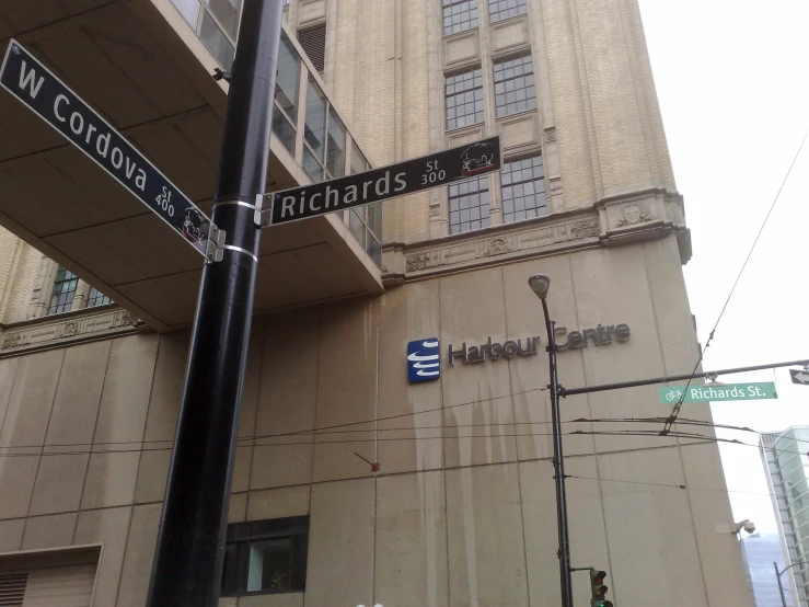 street signs are mounted on the side of a brown building