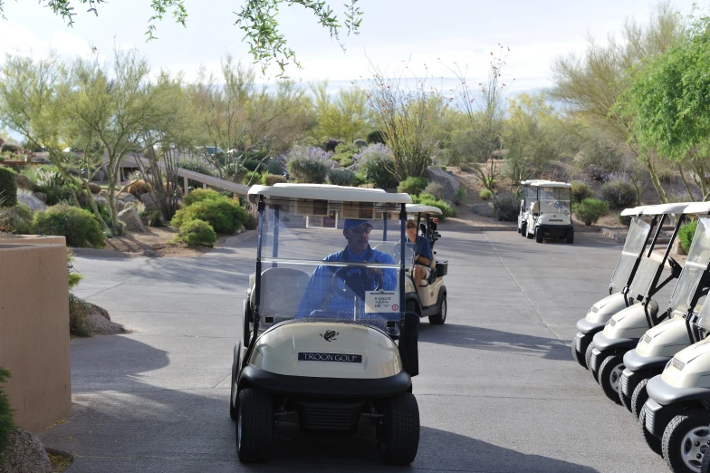 two men riding in carts and golf carts on a road