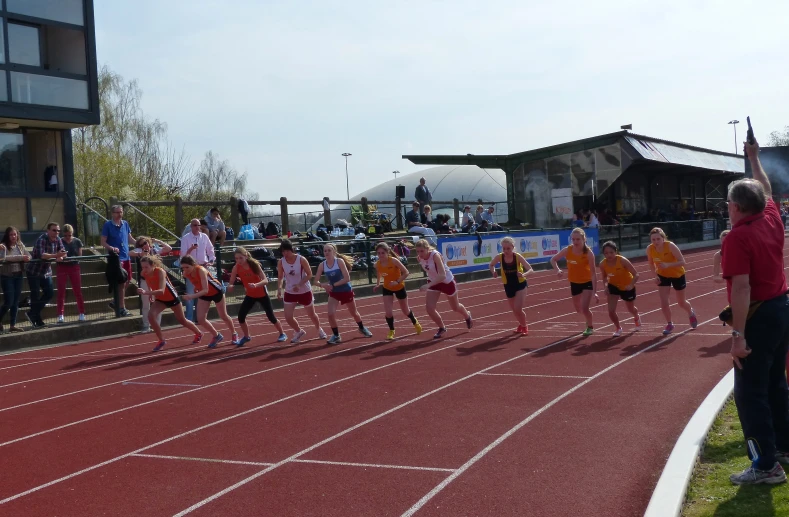 a bunch of children running on a race track