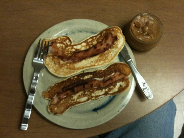 a plate with two breakfast items, a glass of peanut er and pancakes