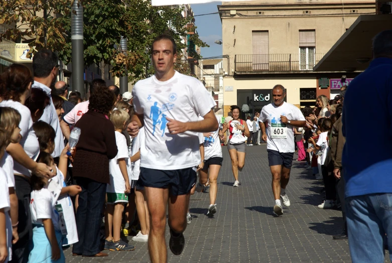 people run down the street, with several wearing t - shirts