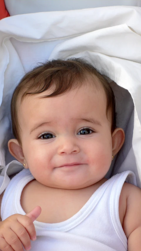 baby showing the middle finger while smiling for camera