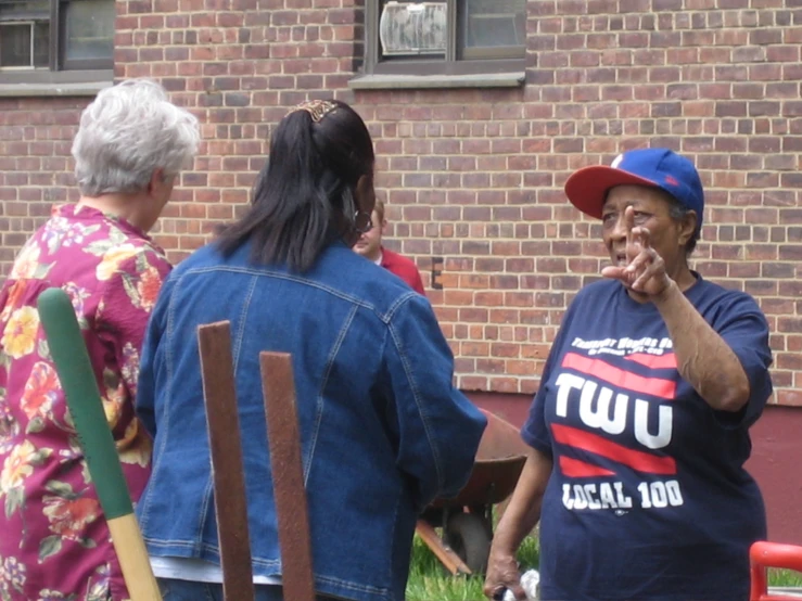 an old woman standing by some people holding soing in her mouth