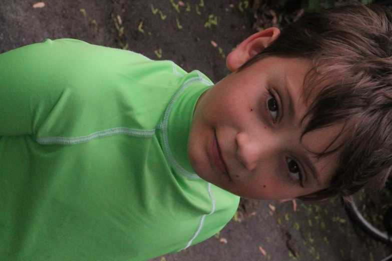 a close up of a child wearing a green shirt
