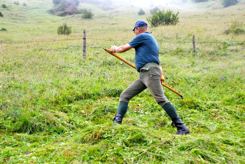 a man using a wooden stick to get up a hill