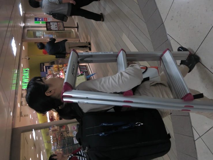 a girl carrying luggage and climbing the steps in a public place