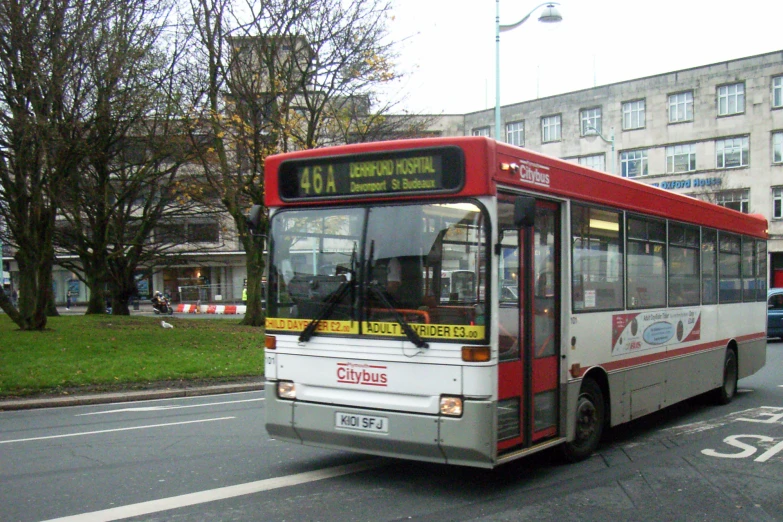 an image of a red and white bus going down the street