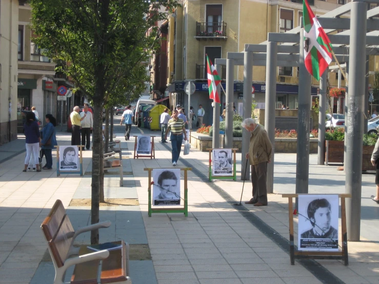 street scene with chairs on the sidewalk and posters on the street