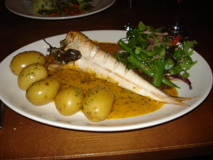 an entree with potatoes and salad on a white plate