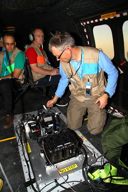 several people sitting in a vehicle are around a dj set