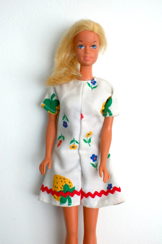 a doll with blonde hair and blue eyes is dressed in a white dress