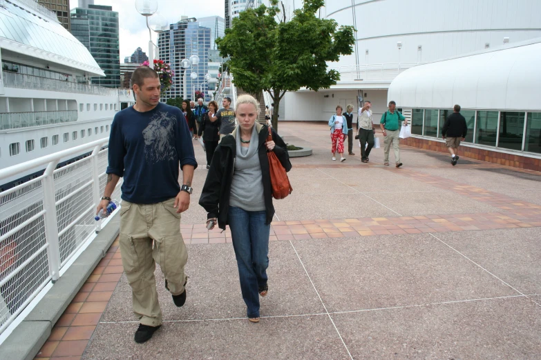 some people walk near each other on the sidewalk