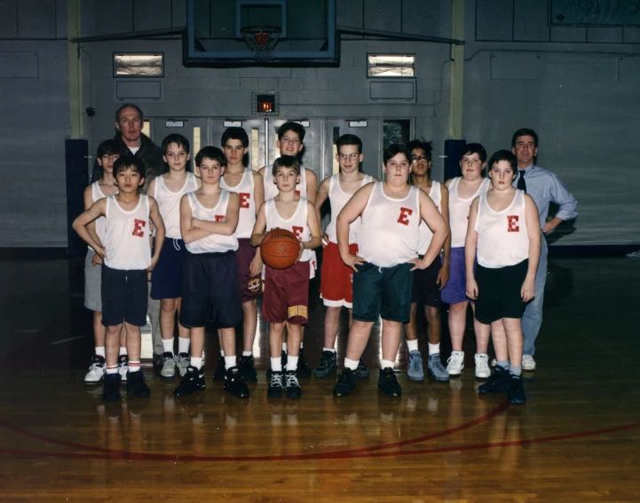 a group of young men standing in front of a basketball