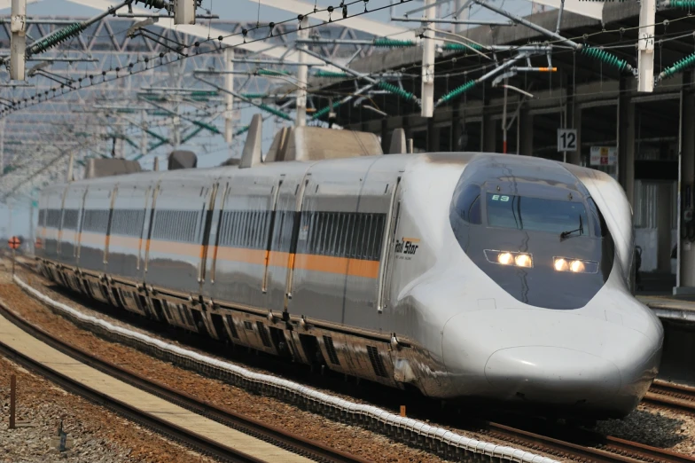 a white train traveling down train tracks under power lines